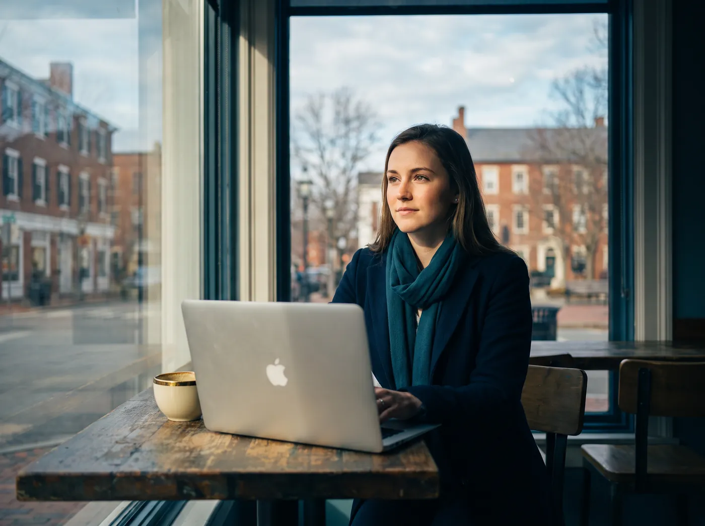 A job seeker working on a laptop at a bright cafe table